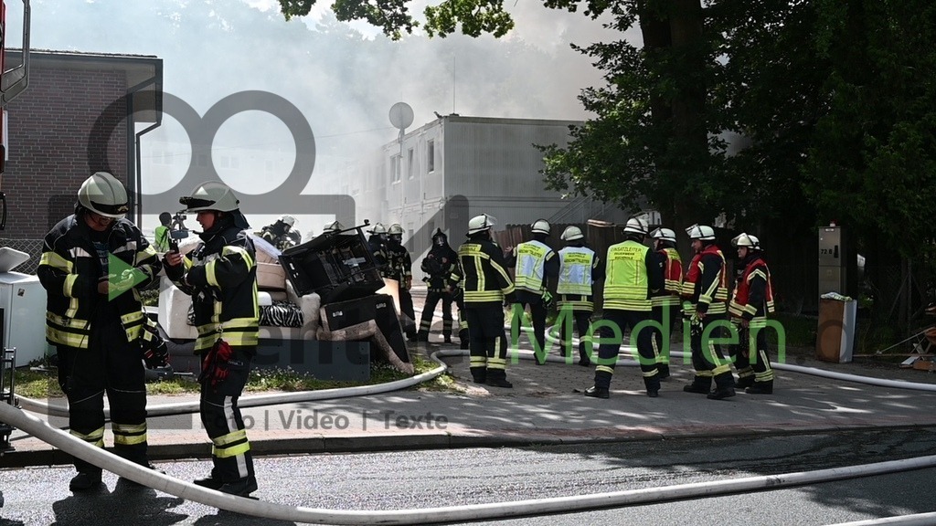 20240708Brand_Gefluechtetenunterkunft_Buchholz6784 | Um 11.28 Uhr wurde ein Brand in einer Geflüchtenunterkunft in Buchholz in der Nordheide gemeldet. Zuvor waren eine Polizeistreife und Mitarbeiter des Heimes in der Unterkunft und wollten einen Streit schlichten. Ein Mann zündete plötzlich Brandbeschleuniger, sofort stand das ganze Zimmer im Vollbrand. Mit schweren Verletzungen können sich der Polizist und eine Mitarbeiterin des Betreibers aus dem Container im Erdgeschoss ins Freie retten. Auch der Bewohner und Brandstifter muss medizinisch versorgt werden. Als die Feuerwehr ankommt, schlagen den Einsatzkräften bereits Flammen entgegen. Sofort wird die. Unterkunft evakuiert, Menschenrettung und Brandbekämpfung eingeleitet. Bei den Nachlöscharbeiten wird eine Person gefunden, er ist tödlich verletzt, die Identität noch unklar. Insgesamt wurden bei dem Brand 20 Bewohnerinnen und Bewohner verletzt. Der Rettungsdienst im Landkreis Harburg war im Dauereinsatz, auch zwei Rettungshubschrauber sind im Einsatz. Buchholz, der 08.07.2024 - Realisiert mit Pictrs.com