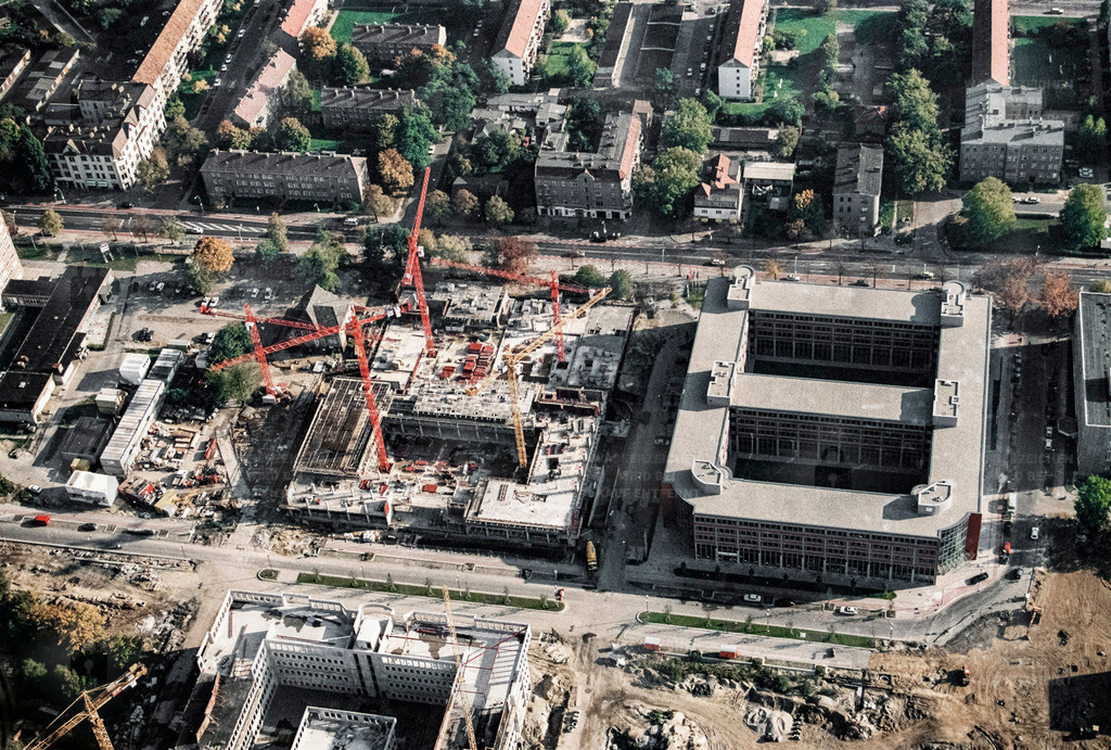 BA 0207_035_MK | 1.09.1994 - Teltow, Gewerbegebiet Oderstraße. Gelände der ehemaligen Carl-von-Ossietzky-Werke (CvO)  Die Entwicklung des Gewerbegebiets, das sich zwischen dem Teltowkanal und der Potsdamer Straße entlang der Oderstraße befindet, begann Anfang der 1990er Jahre. Während der DDR-Jahre waren hier bereits Betriebe wie der VEB Geräte- und Regler-Werke und der VEB Elektronische Bauelemente Car von Ossietzky, um zwei große zu nennen, angesiedelt.Bald nach der politischen und wirtschaftlichen Wende kamen schnell Möbelhäuser, Bau- und Lebensmittelmärkte sowie kleinere Gewerbebetriebe dazu. Teilweise wurden vorhandene Bauten aus der DDR-Zeit abgerissen, aber auch alte, historische Gebäude noch aus der Zeit vor dem Zweiten Weltkrieg saniert und restauriert.Die Privatisierungsbehörde "Treuhand" trifft bemi Zerschlagen der vorhandenen Betriebe, allein 6.000 Beschäftigte der GRW Teltow, eine große Mitschuld. Als zentrales Beispiel gilt die Roland-Ernst-Gruppe aus Heidelberg. Ihr gehört bereits in den ersten 1990er Jahren der größte Teil der Gewerbeflächen Teltows. Die Geräte- und Regler-Werke erhält die Roland-Ernst-Gruppe für 1,00 DM! Und diese dann auch noch frei von Altschulden. Der Wert der GRW wurde non Wirtschaftsprüfern auf 73 Millionen DM und das Firmengelände auf 54 Millionen DM taxiert. Schon 1991 stieg der Wert der Liegenschaft auf das Dreifache des taxierten Wertes, nicht etwa auf den Kaufpreis von 1,00 DM. - Realisiert mit Pictrs.com