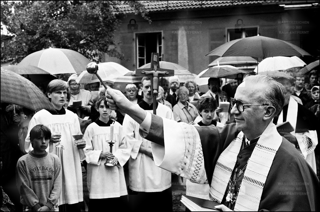 BD 0206_43 | 28.06.1991 - Kleinmachnow, Grundsteinweihe Katholische Kirche  Am 28. Juni 1991 nahm Papst Johannes Paul II. Bischof G. Sterzinsky als Kardinalpriester mit der Titelkirche San Giuseppe all’Aurelio in das Kardinalskollegium auf. Mit der Erhebung des Bistums Berlin zum Erzbistum am 27. Juni 1994 wurde Sterzinsky erster Erzbischof von Berlin und Metropolit der Berliner KirchenprovinzGrundsteinweihe der Katholischen Kirche St. Thomas Morus, Hohe Kiefer 113 am 28.06.1991. Der Neubau der Kirche ersetzt den vorherigen Barackenbau, den die Kirchgemeinde nach dem II. Weltkrieg erwerben konnte.  Die Baracke diente während der Zeit des Nationalsozialismus als Kantinenbaracke den Zwangsarbeitern der Dreilinden-Maschinenbau GmbH, einer Tochter des Boschkonzerns. - Realisiert mit Pictrs.com