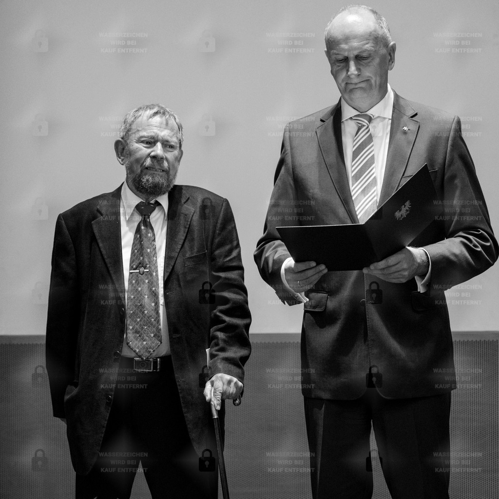 BD 0279_12 | 13.06.2014 - Potsdam Staatskanzlei, Verleihung des Verdienstordens des Landes Brandenburg an Herbert Sander durch den Ministerpräsidenten Dietmar Woidke                                                                        Der Stahnsdorfer Herbert Sander, * 28. Oktober 1938 in Nordhausen; † 4. Januar 2018 in Potsdam, war ein deutscher Maler und Graphiker. Er war der Gestalter des Symbols der unabhängigen Friedensbewegung „Schwerter zu Pflugscharen“ in der DDR.                                                         Nach seinem Studium an der Fachschule für Grafik, Druck und Werbung in Berlin-Oberschöneweide arbeitete Sander als Szenenbildassistent im DEFA-Studio für Spielfilme in Potsdam-Babelsberg. Seit 1967 war er freischaffender Künstler, dessen Werke regelmäßig in Ausstellungen präsentiert und von Museen angekauft wurden. Sander schuf ab 1967 mehr als 40 Jahre lang eine Vielzahl von Plakaten und Designs für Ausstellungen in den Schlössern und Gärten von Potsdam-Sanssouci. Vor allem die Landschaft und die Parks Brandenburgs, aber auch die Reste jüdischer Friedhöfe im Land Brandenburg waren Motive seiner Arbeit. Für die evangelische Auferstehungskirche in seinem Wohnort Kleinmachnow schuf er in den 1980er Jahren ein buntes Kirchenfenster als Mosaik aus vielen bunten Kreuzen und anderen Figuren, darunter Jesus auf einem Esel reitend.Historische Bedeutung erreichte sein Lesezeichenentwurf „Schwerter zu Pflugscharen“, den er 1980 im Auftrag des Landesjugendpfarrers Manfred Domrös nach der Skulptur des sowjetischen Bildhauers Jewgeni Wutschetitsch für die Verwendung in evangelischen Jugendgruppen schuf. Kurze Zeit später erschien das Emblem auf Kleidungsstücken und Taschen und wurde ein sehr verbreitetes Symbol der unabhängigen Friedensbewegung in der DDR. 2014 erhielt Herbert Sander nach Fürsprache von Manfred Stolpe dafür den Verdienstorden des Landes Brandenburg. Zur gleichen Zeit zeigte die Brandenburgische Landeszentrale für politische Bildung eine Werksausstellung.Sander war auch ein Mitbegründer des Neuen Forums in Kleinmachnow. Bei der ersten freien Kommunalwahl kandidierte er dort für Bündnis 90, zog sich dann aber aus der aktiven Kommunalpolitik zurück. In den letzten Jahren lebte er in der Nachbargemeinde Stahnsdorf. Quelle: Wikipedia  Woidke, Dietmar – Politiker, MinisterpräsidentHubert Dietmar Woidke (* 22. Oktober 1961 in Naundorf, Bezirk Cottbus, DDR) ist ein deutscher Politiker der SPD. Er ist seit August 2013 der dritte Ministerpräsident des Landes Brandenburg seit 1990Im Jahr 1993 trat Woidke als 32-jähriger Amtsleiter in die SPD ein, für die er in der Landtagswahl in Brandenburg 1994 ein Direktmandat gewann. Sein Wahlkreis war Spree-Neiße II, den er auch 1999 direkt gewann. Nachdem er 2004 das Direktmandat nicht mehr erringen konnte, und in den Landtag über die Landesliste eingezogen war, trat er zur Landtagswahl 2009 im Wahlkreis Spree-Neiße I an und gewann ihn direkt. Bei der Landtagswahl 2014 gewann er den Wahlkreis erneut direkt mit 49,5 Prozent der Stimmen. 2019 gewann er ihn wiederum direkt, dieses Mal mit 36,2 Prozent der Stimmen.Im Landtag war er von 1994 bis 1999 stellvertretender Vorsitzender des Ausschusses für Ernährung, Landwirtschaft und Forsten und von 1999 bis 2004 Mitglied des Ausschusses für Landwirtschaft, Umweltschutz und Raumordnung. Zeitweise leitete er den Braunkohlenausschuss des Landes Brandenburg. Nachdem er 2009 nicht für das Landeskabinett berücksichtigt worden war, übernahm er von November 2009 bis zu seiner Berufung als Innenminister im Oktober 2010 das Amt des Fraktionsvorsitzenden der SPD-Fraktion und wurde Mitglied des Präsidiums des Landtags. Von Dezember 2009 bis November 2010 war er außerdem Vorsitzender des Hauptausschusses des Parlaments.Von 1998 bis 2003 war er außerdem Stadtverordneter in Forst (Lausitz) und gehörte von 1998 bis zu seiner Ernennung zum Minister im Jahr 2004 dem Kreistag des Landkreises Spree-Neiße an. Bei der Kommunalwahl im Jahr 2008 wurde Woidke wiederum als Stadtverordneter in die Stadtverordnetenversammlung von Forst (Lausitz) sowie als Abgeordneter in den Kreistag Spree-Neiße gewählt. Diese Mandate gab er im Oktober 2010 im Zusammenhang seiner Ernennung zum Innenminister des Landes Brandenburg zurück.Am 26. August 2013 wurde Woidke als Nachfolger von Matthias Platzeck zum Vorsitzenden des SPD-Landesverbandes Brandenburg gewählt.[6] Auf dem ordentlichen Parteitag der SPD vom 14.–16. November 2013 in Leipzig wurde Woidke als Beisitzer in den Bundesvorstand der SPD gewählt. - Realisiert mit Pictrs.com